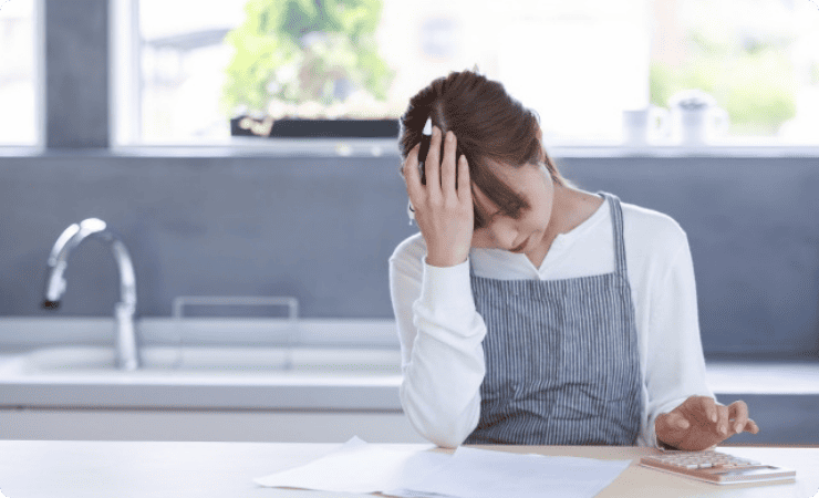 電卓を叩く頭を抱えた女性