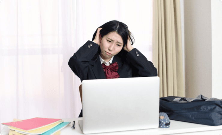 頭を抱える学生服姿の女性