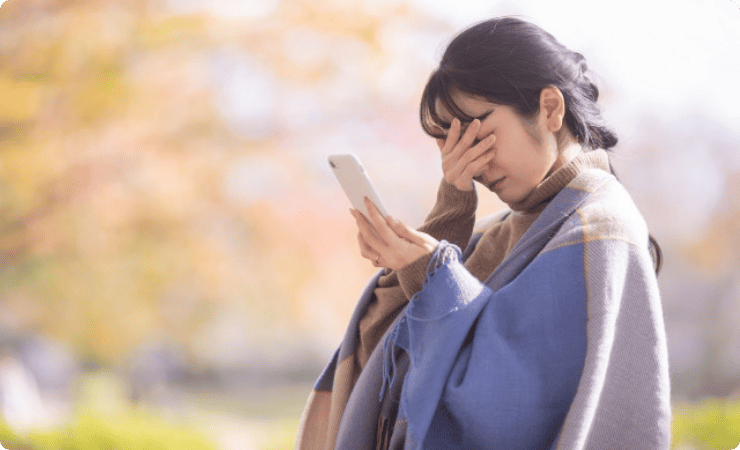 スマホ画面に目を伏せる女性