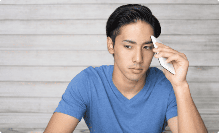 スマホをおでこに当て悩む男性