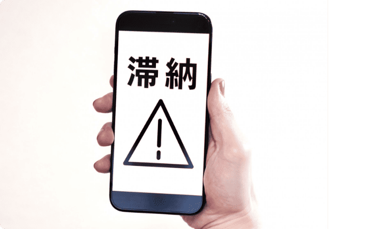 スマホ画面に滞納マークが表示されている