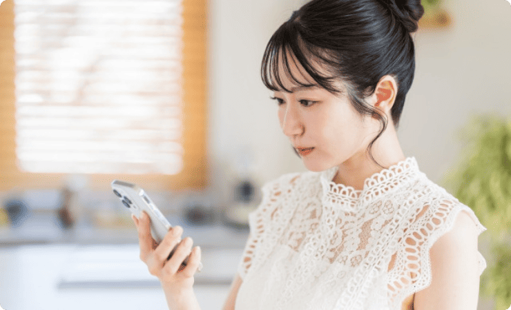 スマホ画面を見つめる女性